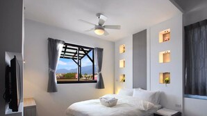 A modern bedroom with a bed, a ceiling fan, a window with curtains, and wall-mounted lights. - Wo House (Puli)