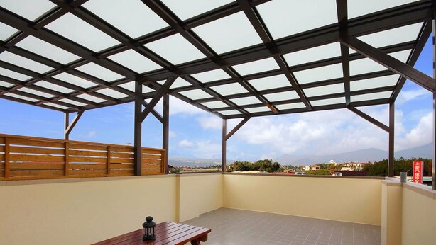 A covered outdoor balcony with a wooden fence, a table, and a lantern. - Wo House (Puli)