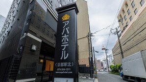 A hotel sign with Japanese characters, a contact number, and a website URL.