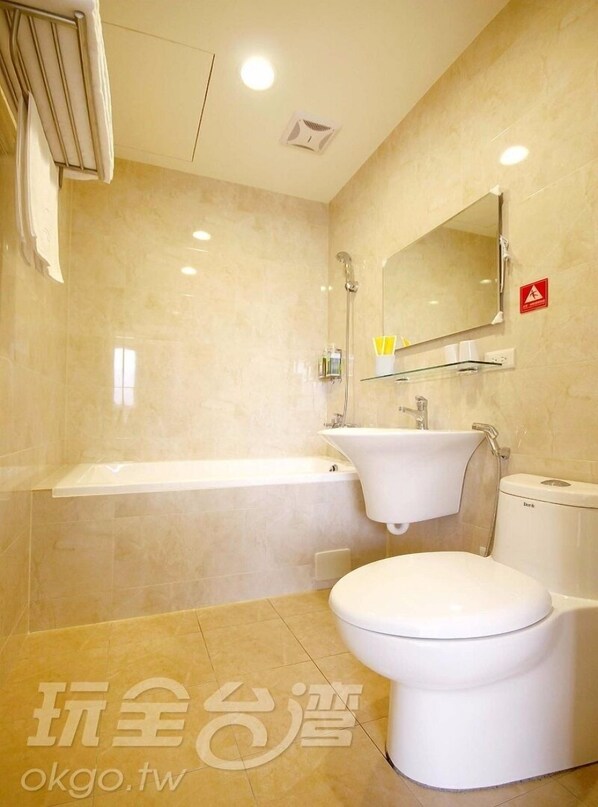 Un baño moderno con bañera, lavamanos e inodoro.