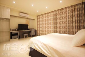 A hotel room with a bed, a desk with a TV, a chair, and a wardrobe. - Wo Villa (Puli)