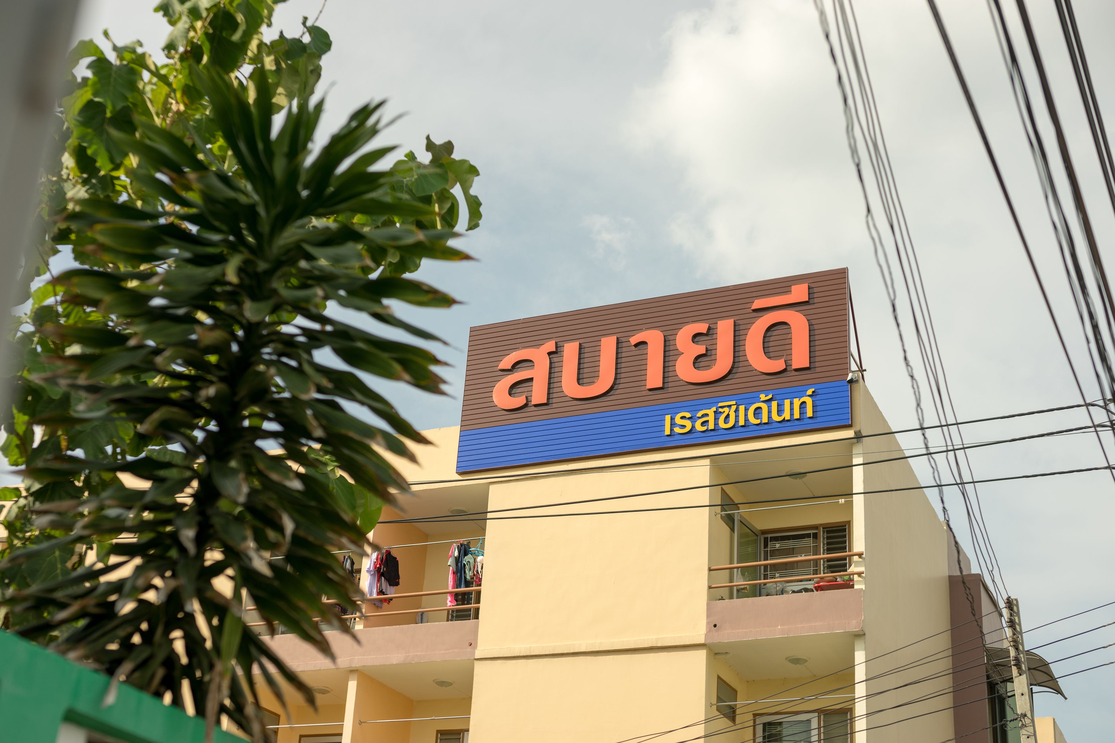 A building with a sign that reads "Isaan Café" in English and another language.