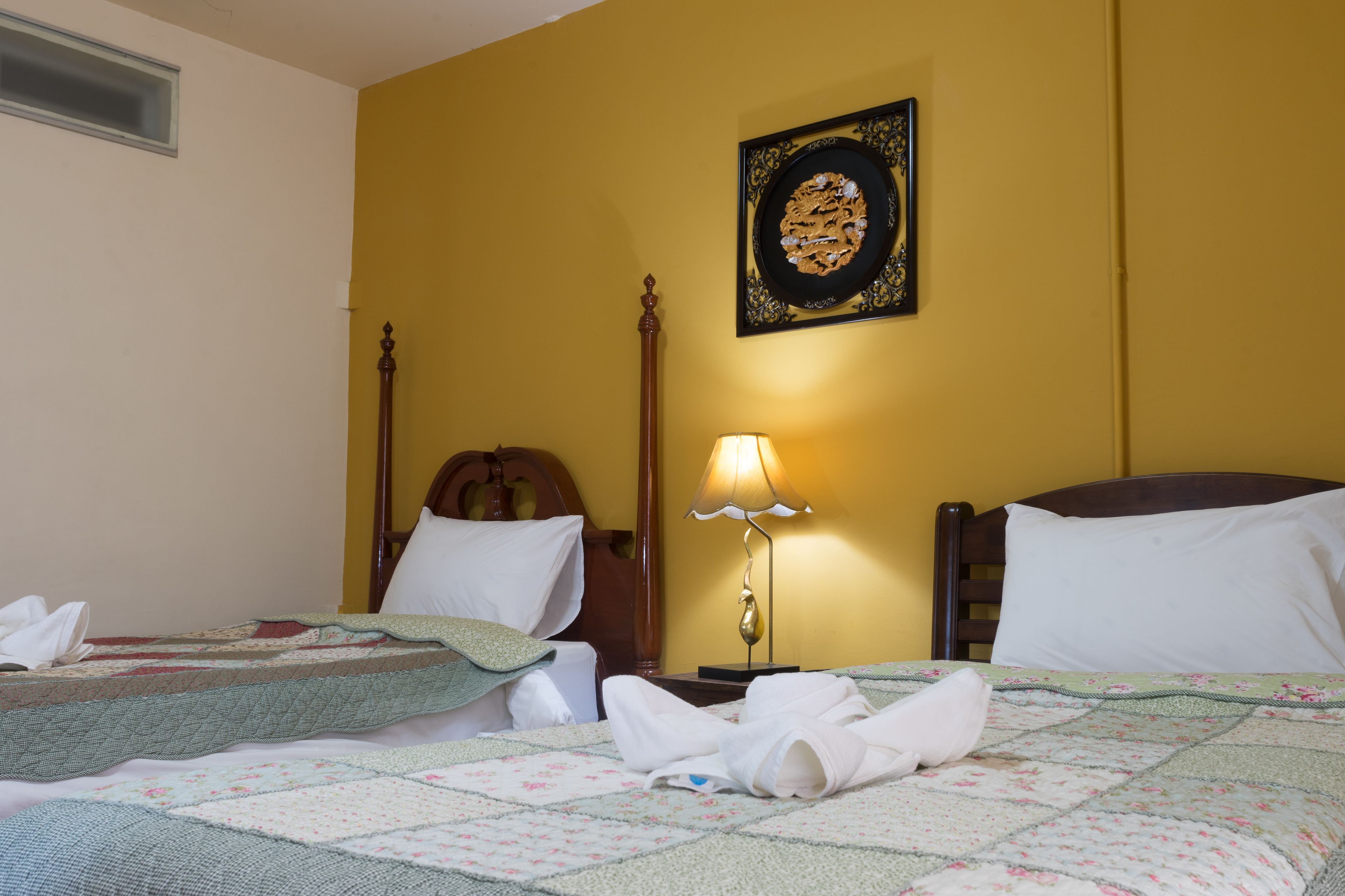 A hotel room with a bed, a bedside lamp, and a wall-mounted picture.