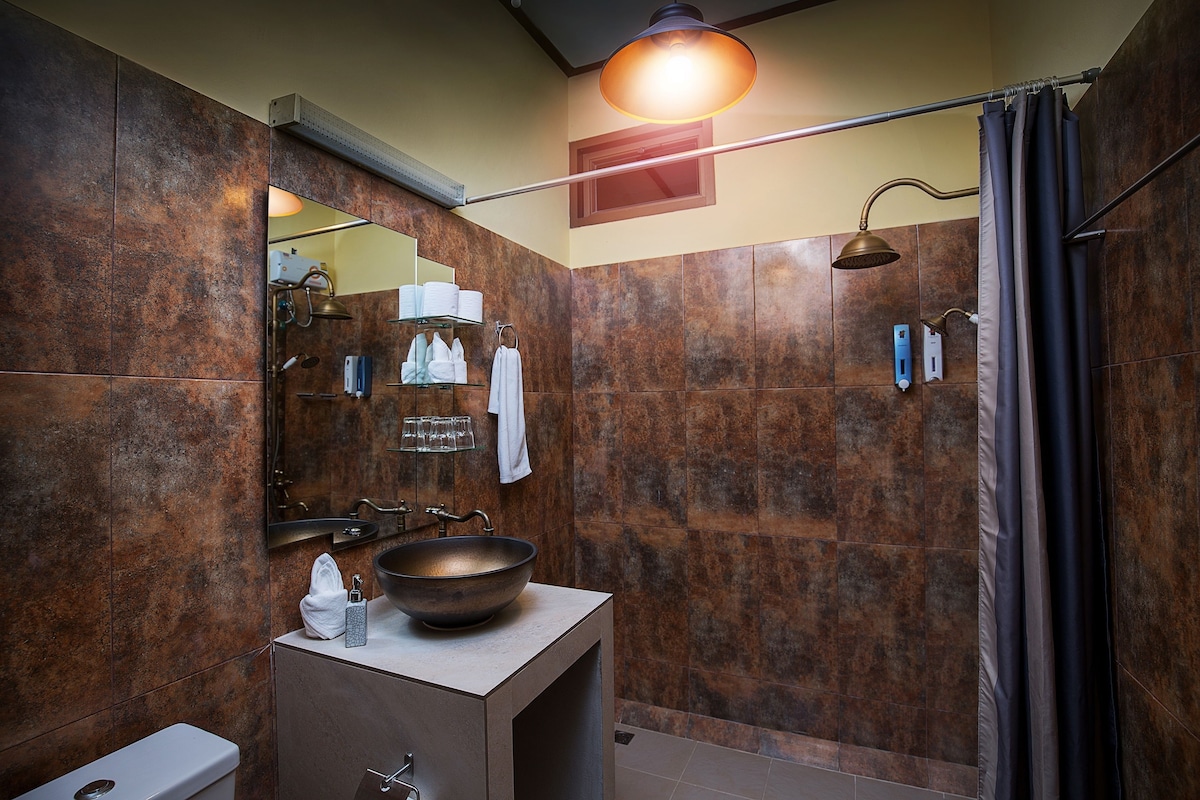Un baño moderno con un lavamanos grande, un espejo y ducha.