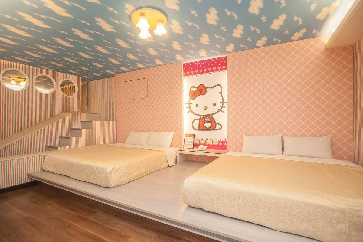 A room with two beds, a Hello Kitty poster, a staircase, and a patterned wall.
