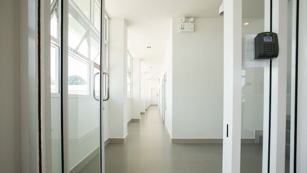 A clean, modern hallway with glass doors and a security keypad on the wall. - J-House Phetchaburi (Phetchaburi)