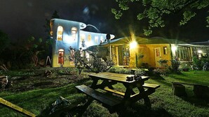A building with a unique architectural design featuring arched windows and a curved roof, illuminated by warm lighting. - Moonlight Pension (Seogwipo)