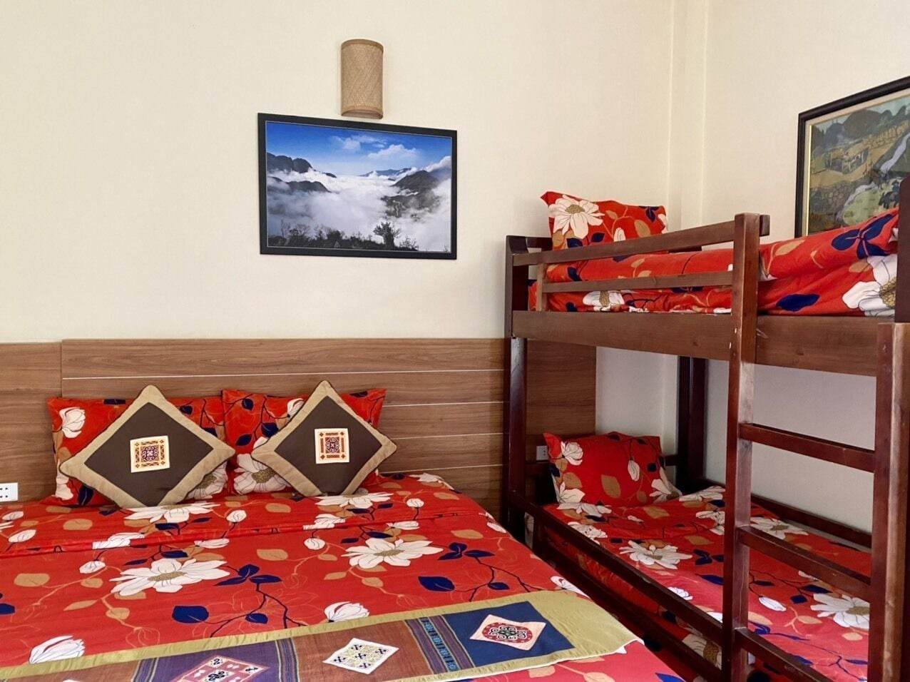 A bunk bed room with a wooden headboard, floral bedding, and a framed picture on the wall.