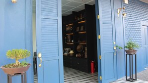 Una puerta azul que da paso a un suelo con estampado de cuadros.