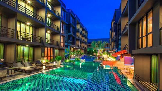 A hotel with a swimming pool, lounge chairs, and a covered seating area. - Aspira Residences Samui (Koh Samui)