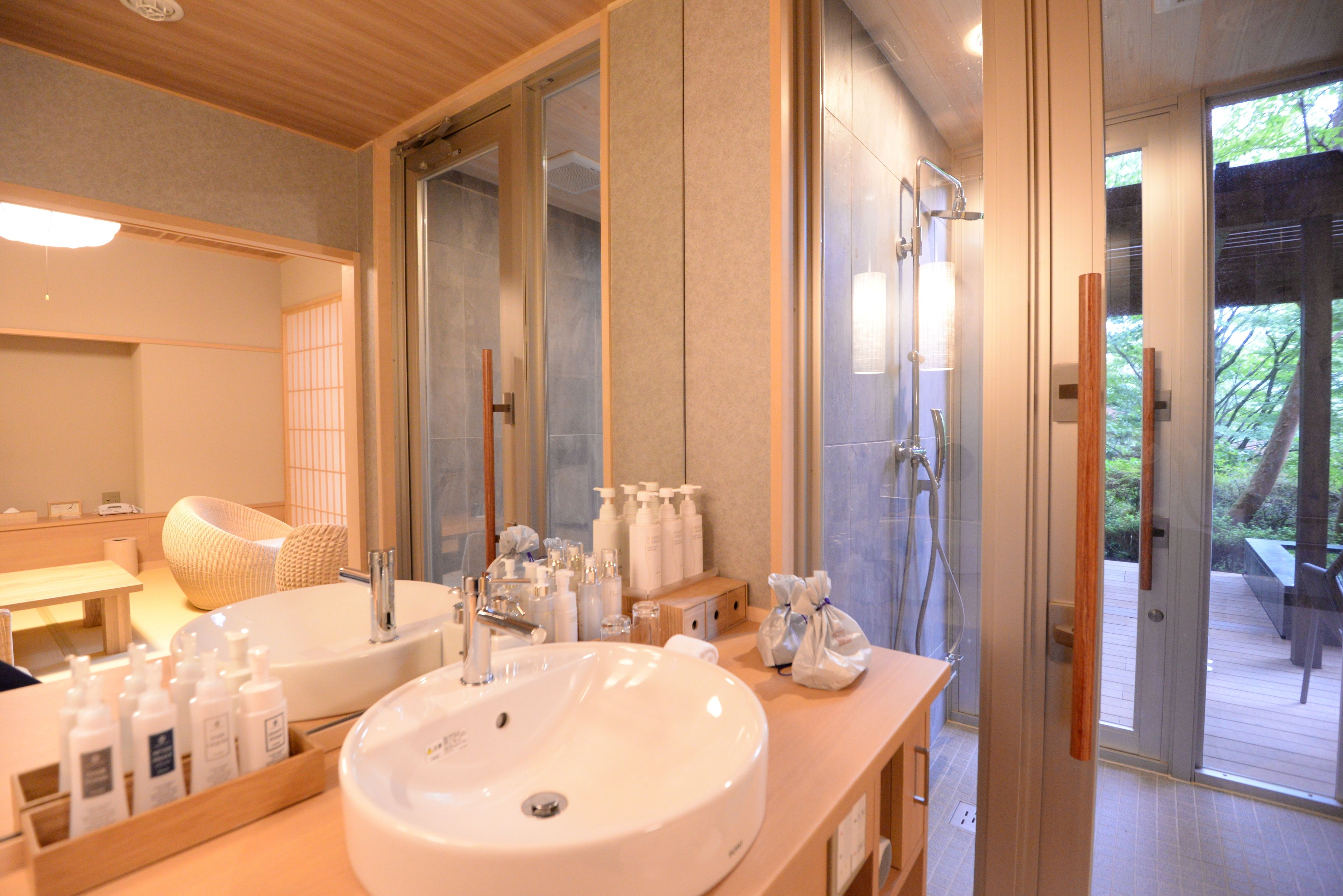 Une salle de bain moderne avec un grand lavabo, un miroir et une douche.