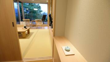 A room with tatami flooring, a low wooden table, and a small shelf with a decorative item.