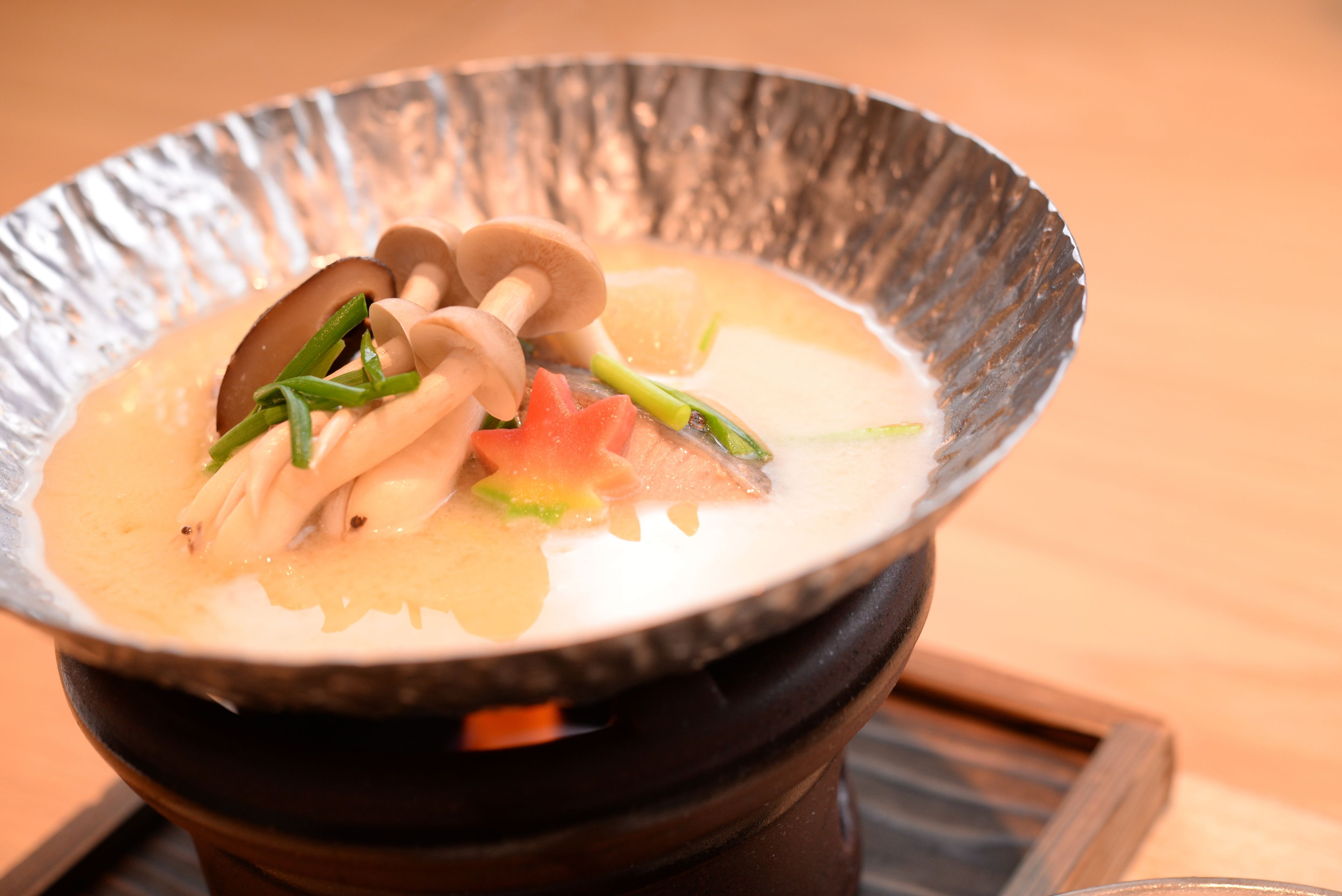 A bowl of soup with vegetables and mushrooms.