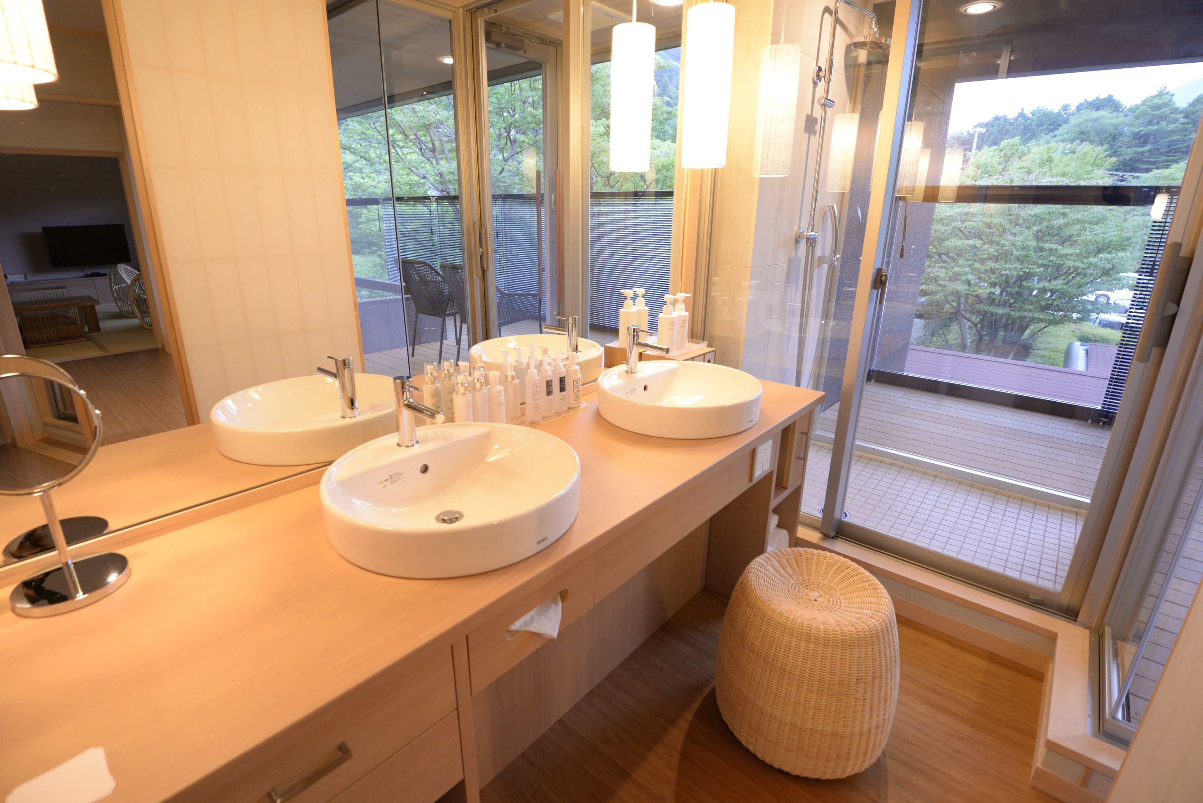 A modern bathroom with two sinks, a large mirror, and a glass shower enclosure.