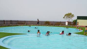 Guests can enjoy a refreshing swim in the pool surrounded by lush greenery and a clear view of the surrounding landscape.