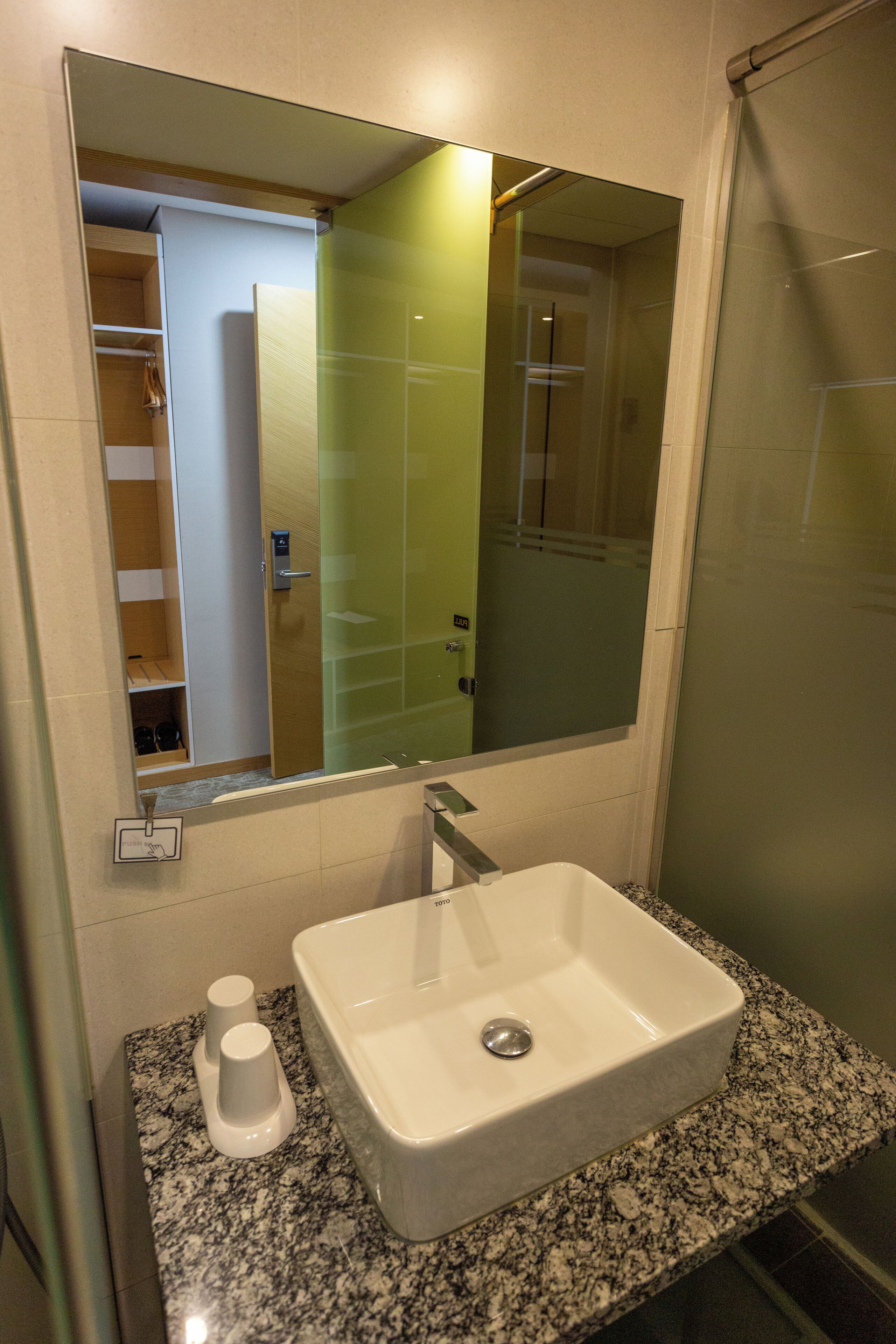 A bathroom with a white sink, a mirror, and a shower.