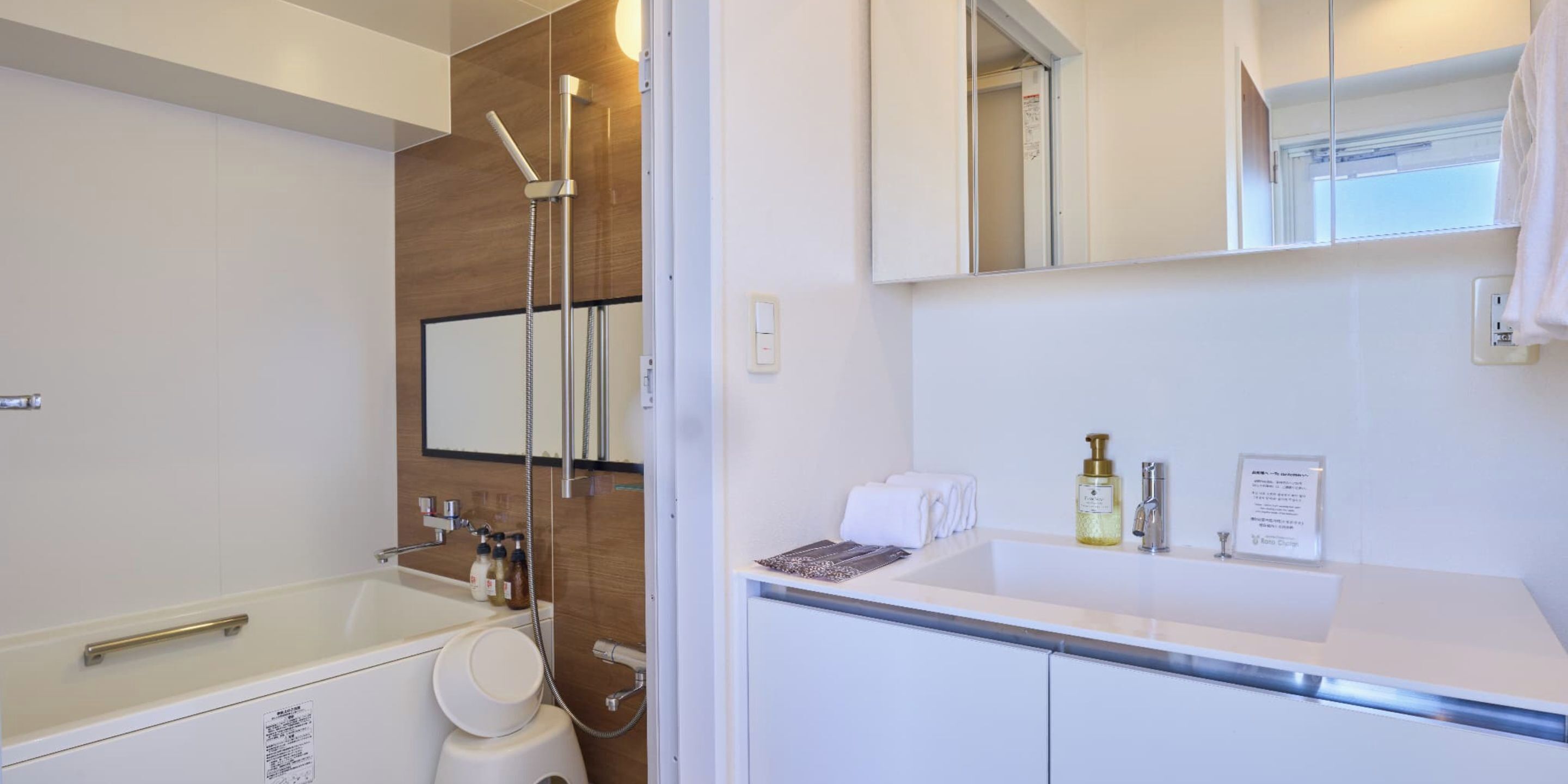 Un bagno moderno con vasca, doccia, lavandino e specchio.