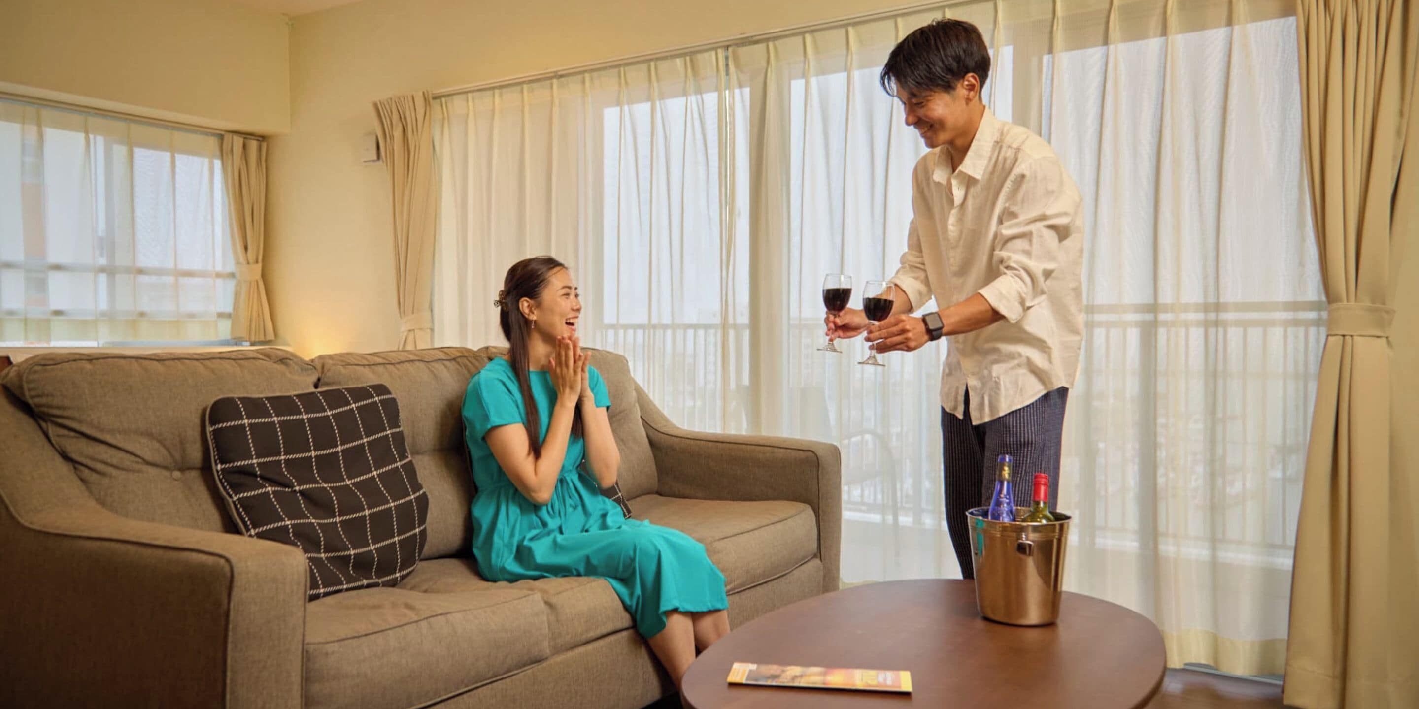 Una habitación con sofá, una mesita de café y una botella de champán.
