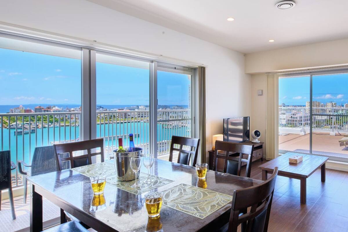 A spacious balcony with a city view, a dining area with a table and chairs, and a sofa.