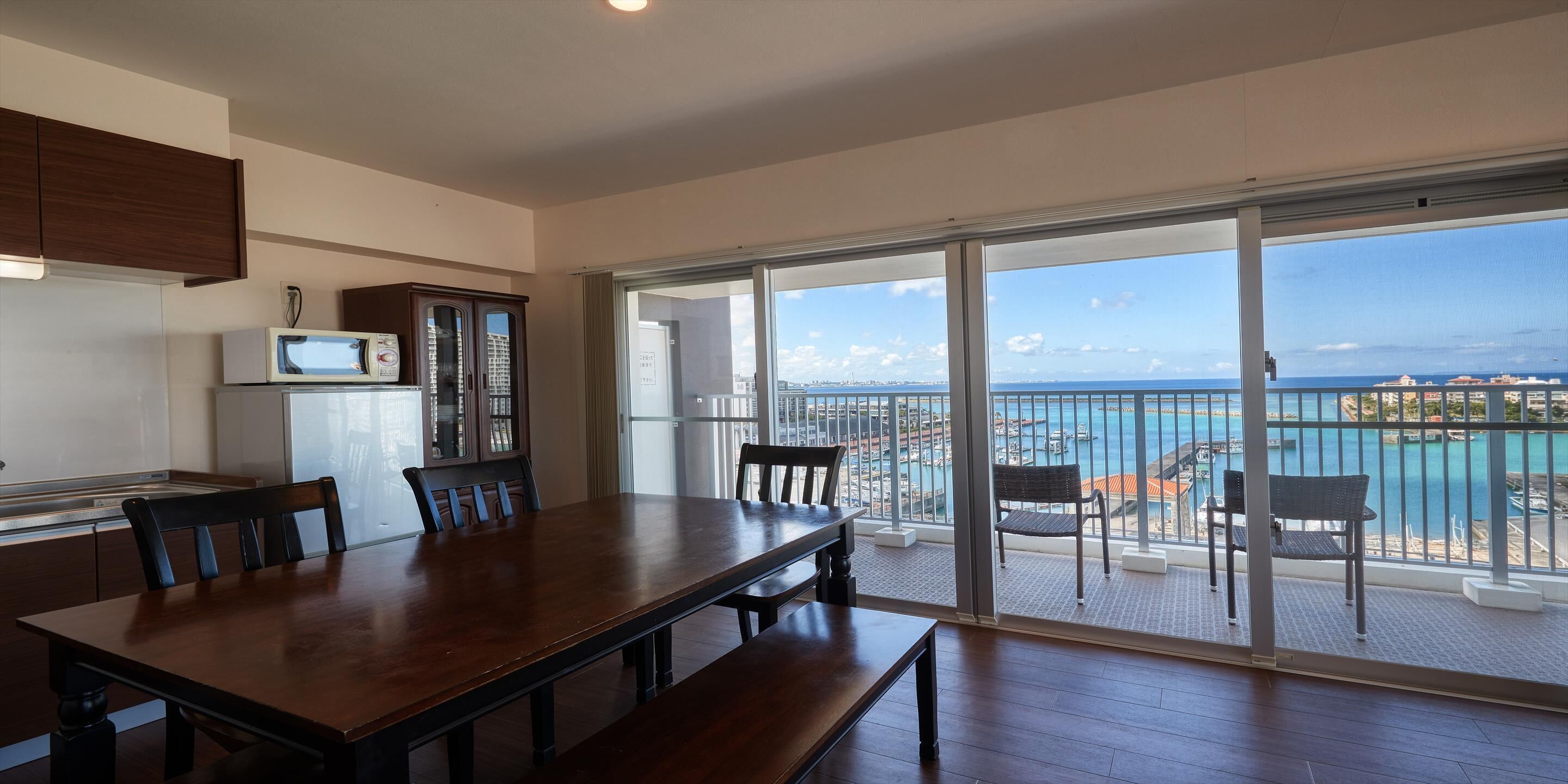 A spacious balcony with a view of the sea and cityscape.