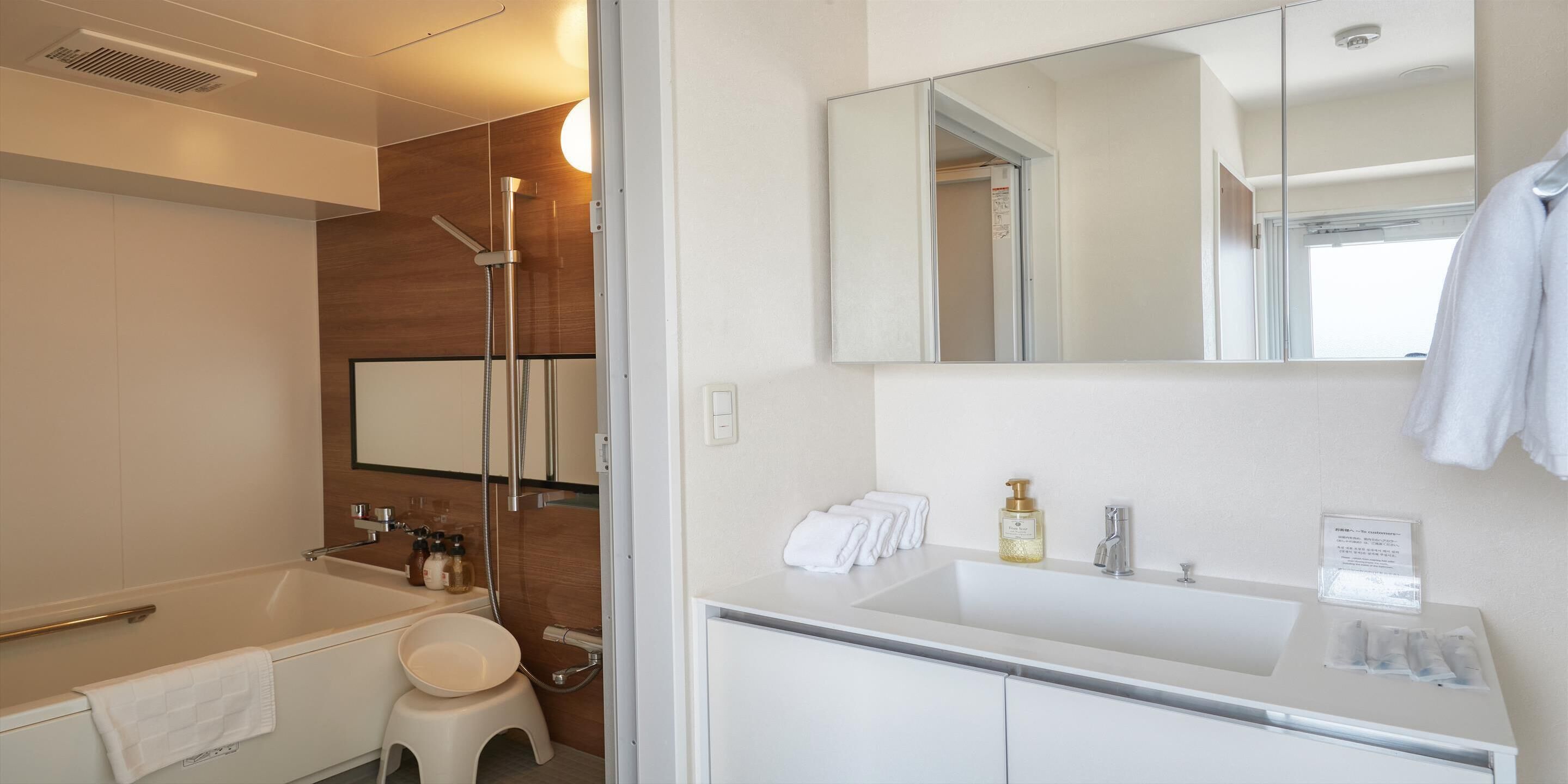 Un baño moderno con bañera, ducha y un espejo grande.