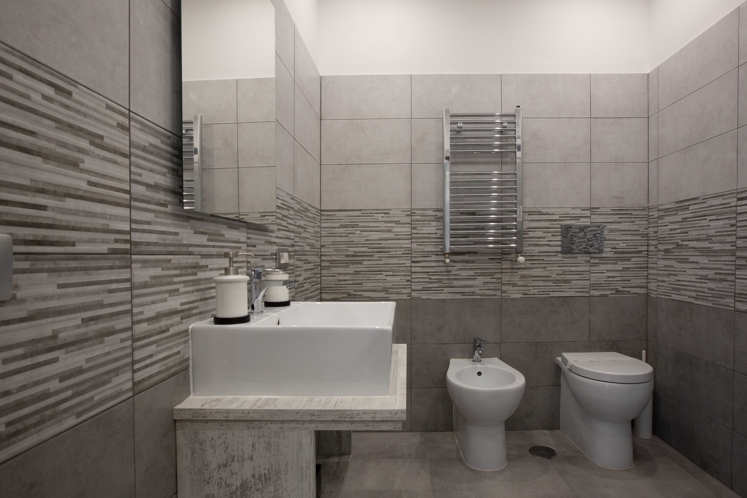 A modern bathroom with a large bathtub, a bidet, and a toilet.