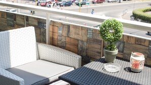 A balcony with wicker furniture, a potted plant, and a lantern. - Vatican City Relais (Rome)