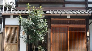 A traditional Japanese building with a tiled roof, wooden sliding doors, and a small tree in front. - Shimoza-an Kamanza-Tei (Kyoto)