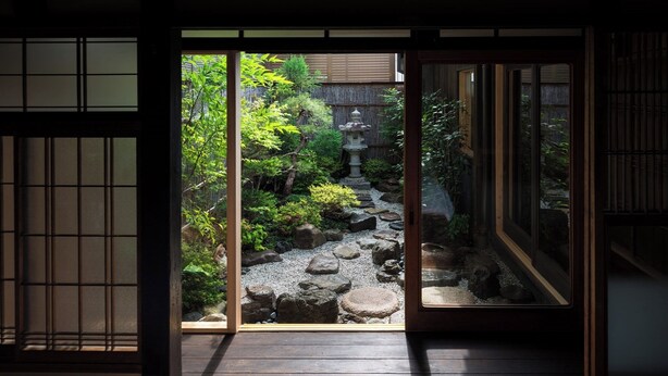 A traditional Japanese garden with a stone path, rocks, and a small water feature. - Shimoza-an Kamanza-Tei (Kyoto)