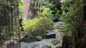 A garden with a stone pathway, rocks, and various plants. - Shimoza-an Kamanza-Tei (Kyoto)