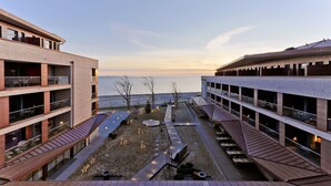 A modern hotel with multiple floors, outdoor seating areas, and a view of the sea. - Upstalsboom Wyk auf Föhr (Wyk auf Foehr)