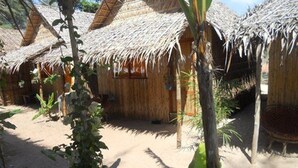 A thatched-roof structure with a simple, open layout, surrounded by natural vegetation. - Chez Paou (Sihanoukville)