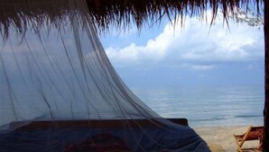 A beach tent with a canopy, a bed, and a view of the sea. - Chez Paou (Sihanoukville)