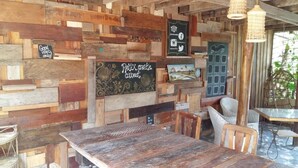 A rustic interior with wooden walls, a chalkboard with 'Relax create connect' written on it, and a door with a heart design. - Mangroves & More (Sihanoukville)