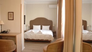 Een hotelkamer met een groot bed, een bureau met een lamp en een stoel.