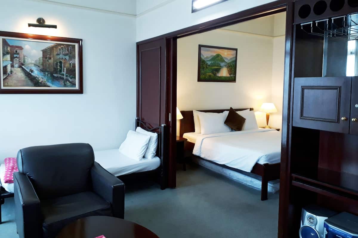 Una habitación de hotel con una cama, una silla, una mesa y un cuadro en la pared.