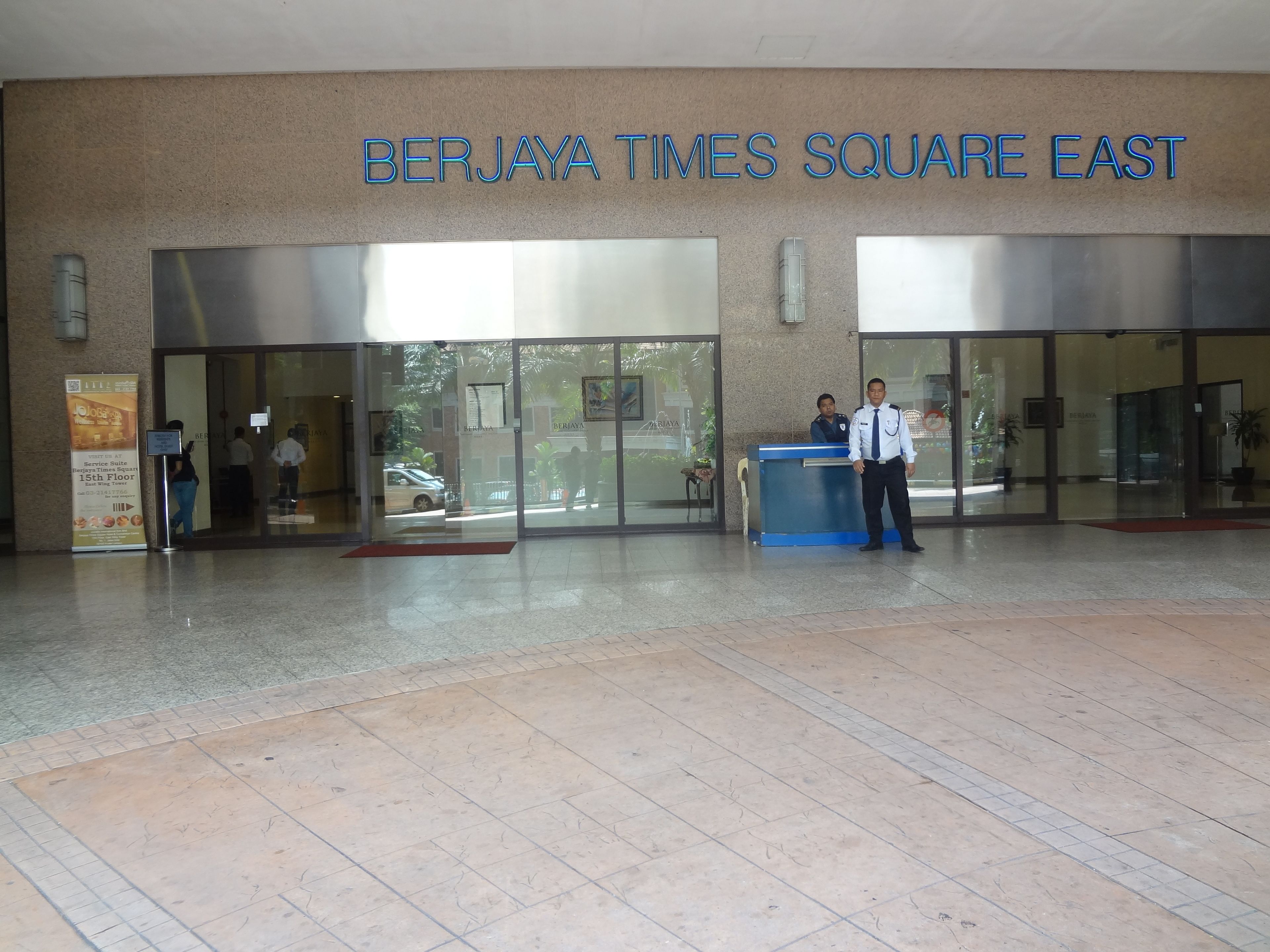 The entrance to Berjaya Times Square East with a reception desk and two uniformed personnel.