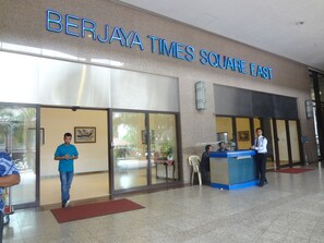 The exterior of Berjaya Times Square East with a reception desk and a glass entrance.