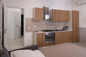 Une cuisine compacte avec des meubles en bois, une cuisinière en acier inoxydable et un four encastré.