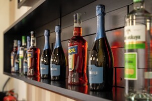 Una hilera de botellas de vino sobre una estantería.
