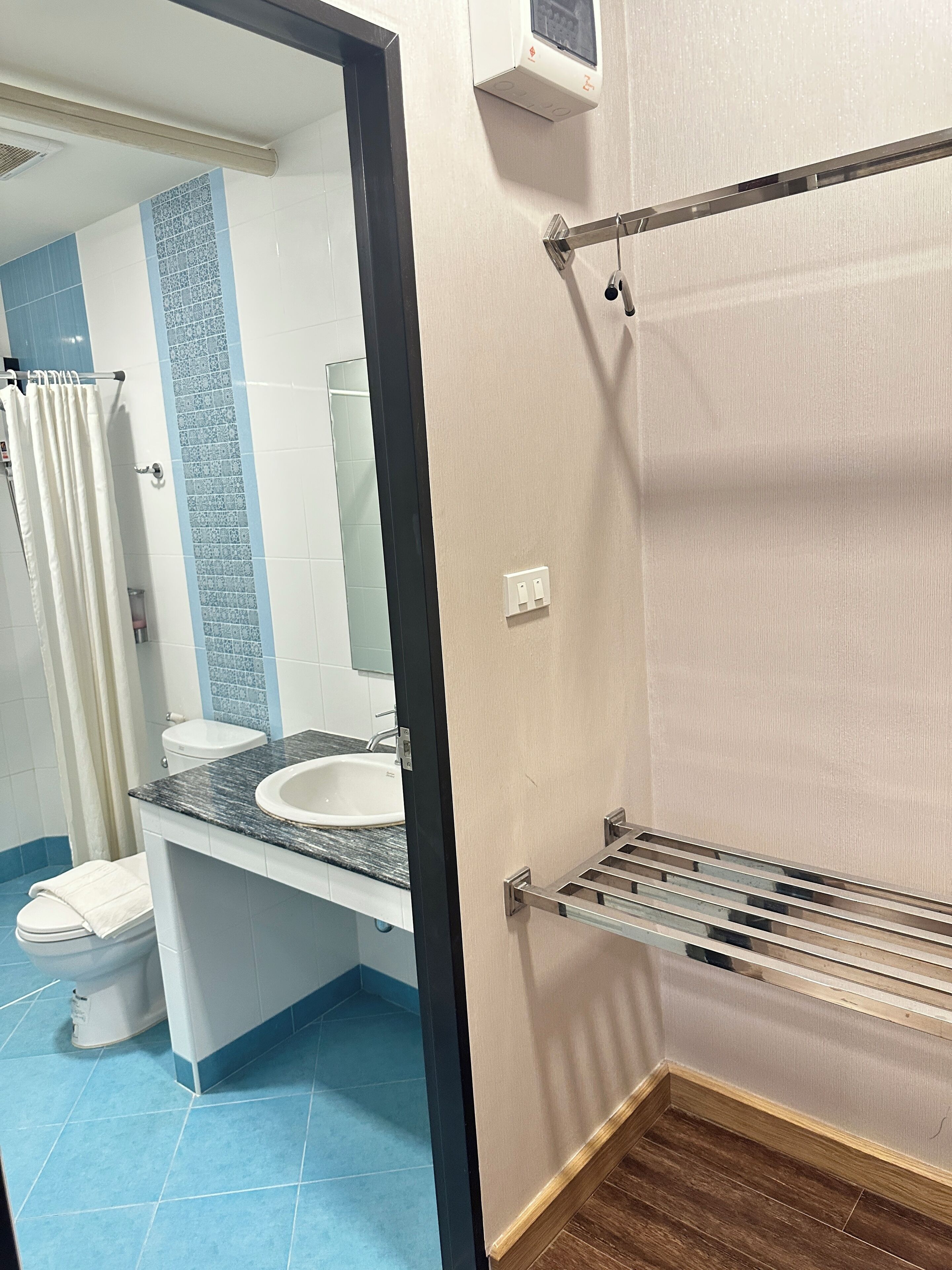 A bathroom with a sink, mirror, and towel rack.