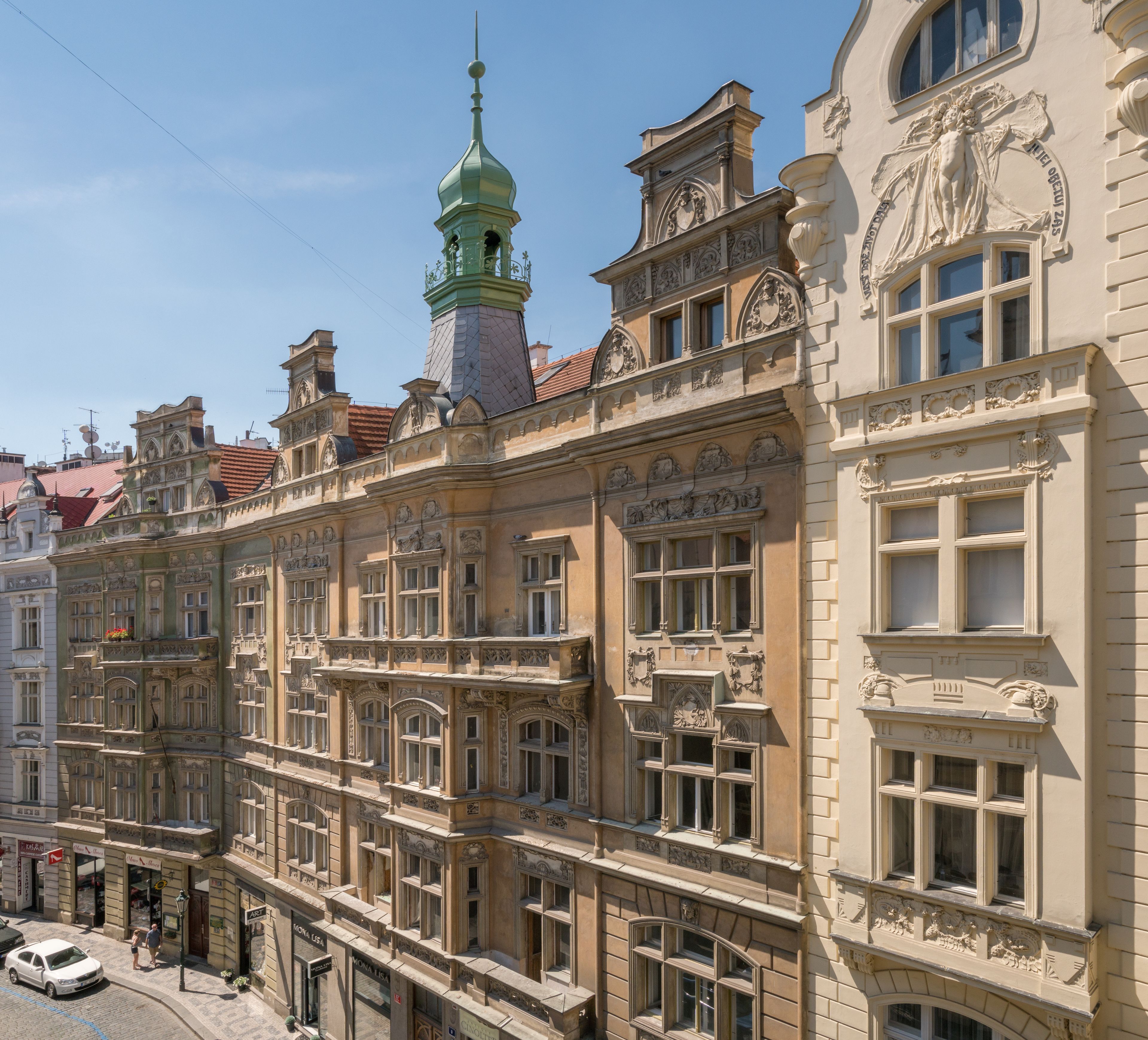 A historic building with ornate architectural details, including a green-domed tower and multiple windows.