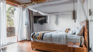 A bedroom with a wooden ceiling, a bed with a canopy, a TV, and a bedside table. - Hemingways Retreat Kigali (Kigali)