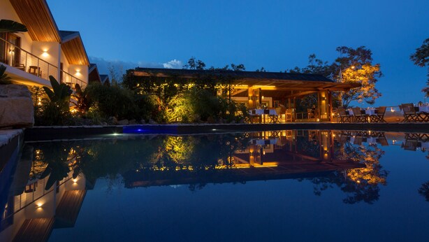 A modern resort with a pool reflecting the building and surrounding trees. - Hemingways Retreat Kigali (Kigali)