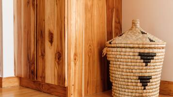 A wooden floor, a woven basket with a lid, and a wooden door.