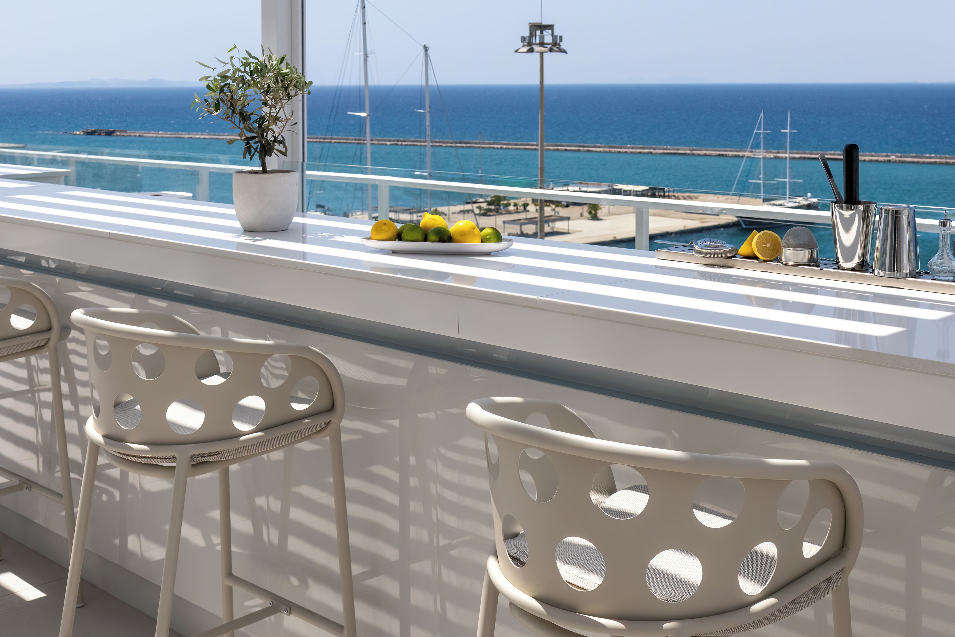 Eine Bar mit Meerblick, einem Blumentopf und einer Zitronentellerm.