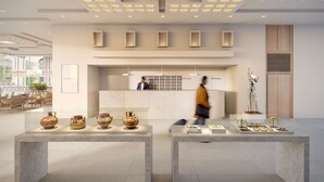 Un moderno vestíbulo de hotel con un mostrador de recepción, mesas de mármol y una exhibición de cerámica.