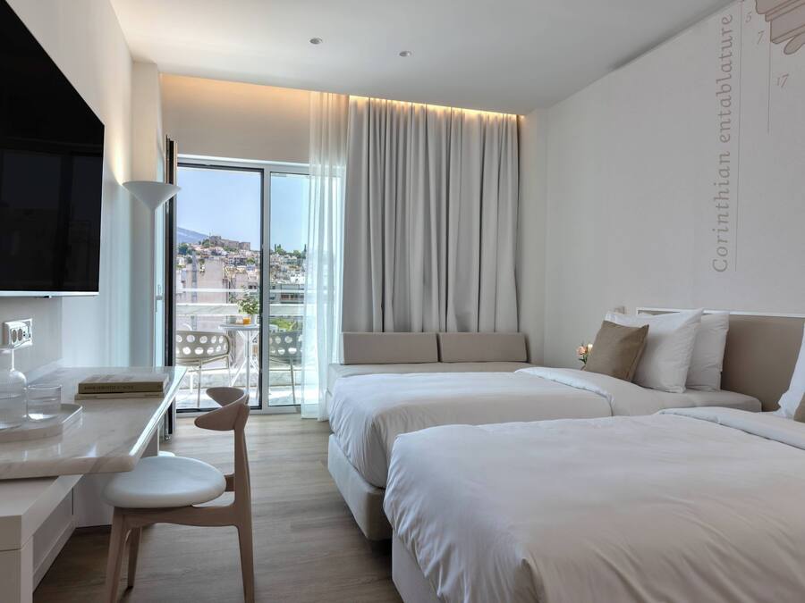 A hotel room with a bed, bedside table, and a TV.
