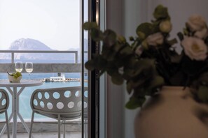 A balcony with a table, two glasses, and a vase with flowers. - Mercure Patras Astir (Patras)