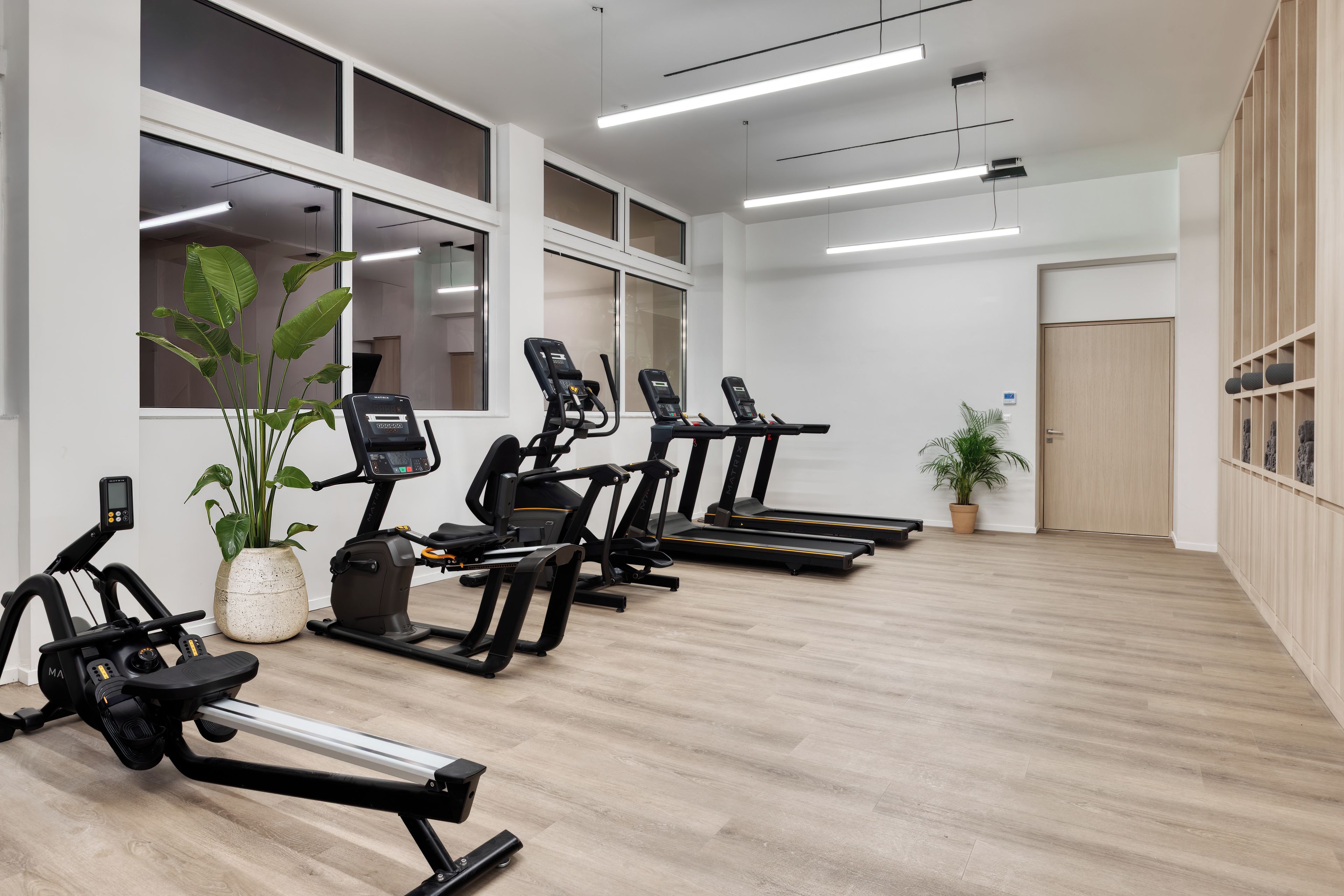 Ein Fitnessstudio mit Laufbändern, Ergometer und Rudergerät.